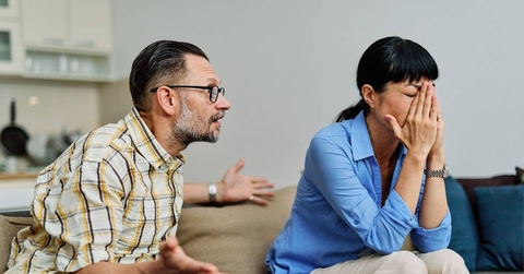 Two people arguing on couch in living room