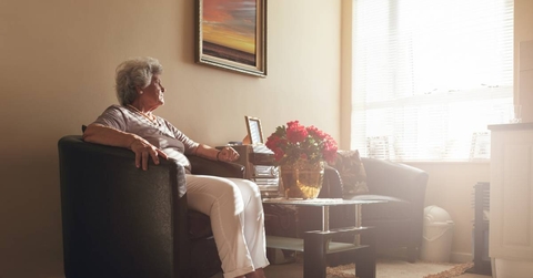 Senior woman sitting alone on a chair at home