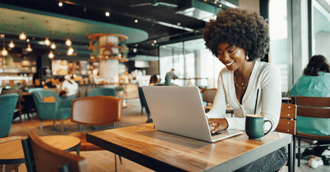 Young woman on laptop at coffee shop