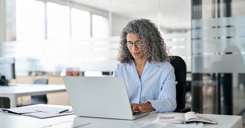 Middle aged business woman on laptop in office