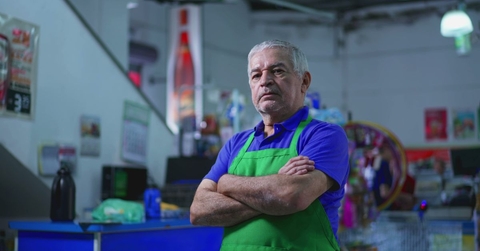 Older supermarket manager with crossed arms