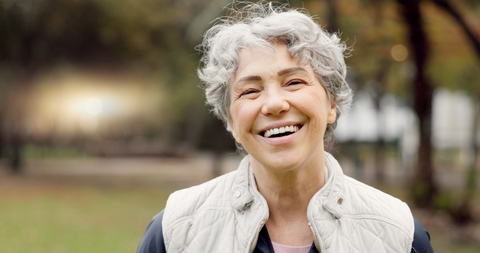 Happy woman in her 60s with short white hair smiling