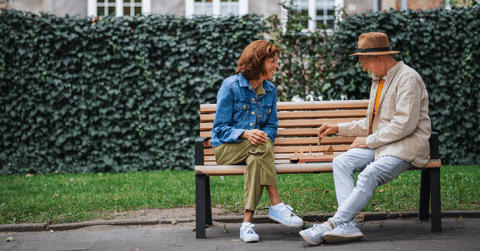 Older couple playing chess on bench