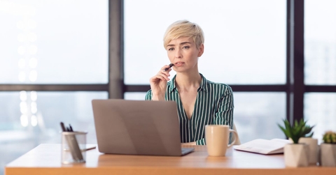 Business woman in her 40s with laptop, thinking
