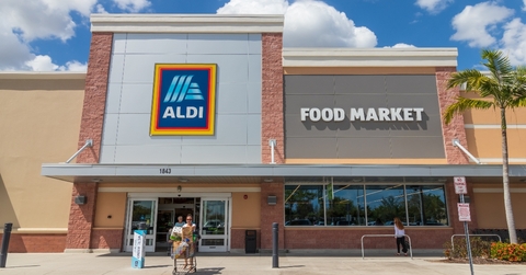 Aldi store front and shoppers coming out of it pushing a cart