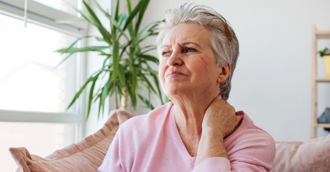 Woman in her 70s looking worried and in pain