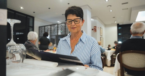 senior woman is sitting at a restaurant table