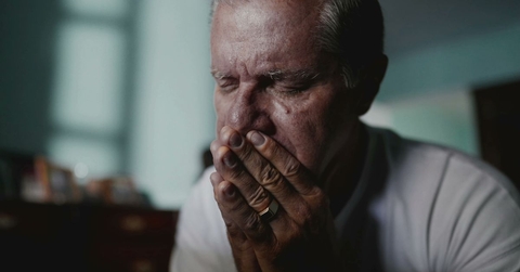 Portrait of older man with face in hands