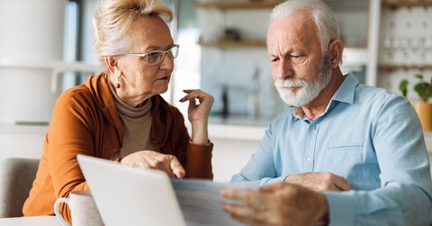 Senior couple reviewing paperwork in kitchen