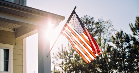 American flag on home with sun in background
