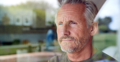 Pensive looking mature man looking out window