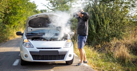 An anxious man near a broken car on the road