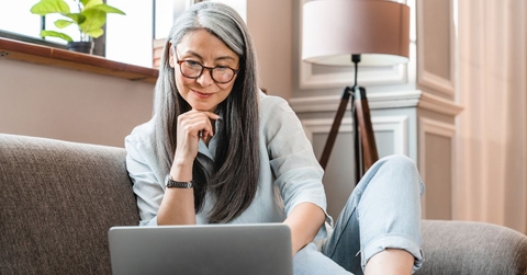 Older woman on couch with laptop