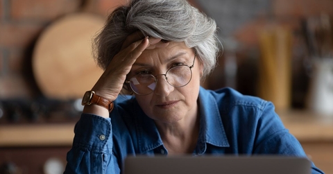 Stressed older woman on laptop