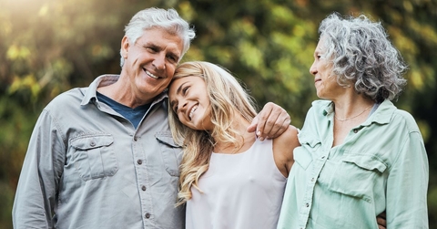 Senior couple embracing adult daughter