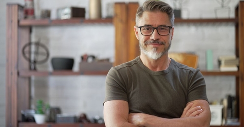 Smiling man in his 40s with crossed arms