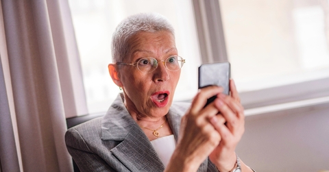 Older woman shocked looking at phone screen