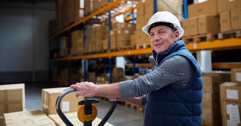 Older male warehouse worker smiling