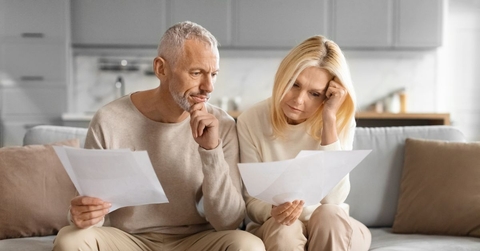 Mature couple on couch reviewing papers