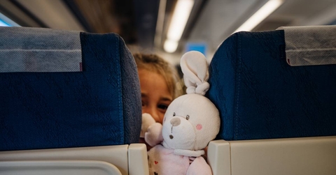 Child peeking between seats on airplane