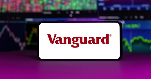 Vanguard displayed on mobile phone with stock market chart background