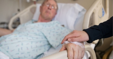 holding hands with elderly patient at hospital