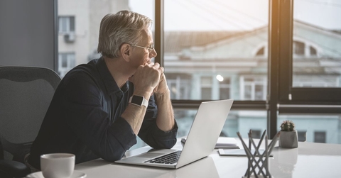Pensive looking mature man with laptop
