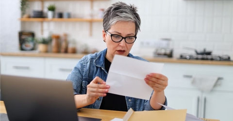 Shocked mature woman holding letter