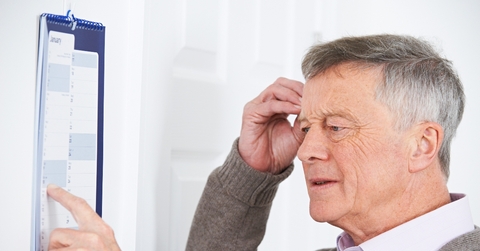 Older man looking at calendar confused