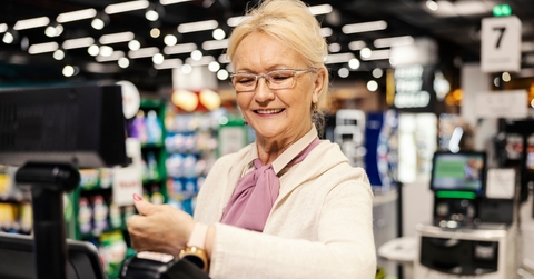 Senior paying at self-checkout of grocery store