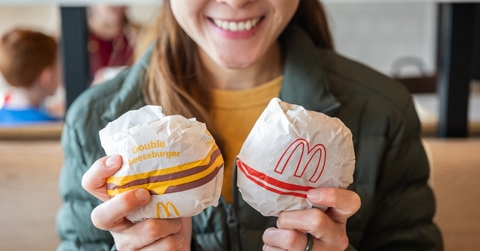Woman smiling and holding two burgers from McDonalds