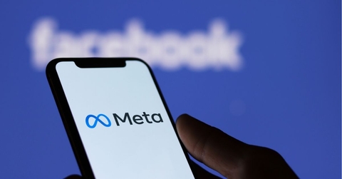 Meta logo on smartphone screen and Facebook logo background