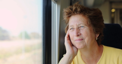 Woman in her late 70s looking through the window