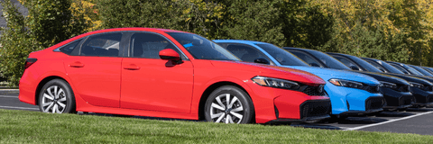 Honda civics in line at dealership outside