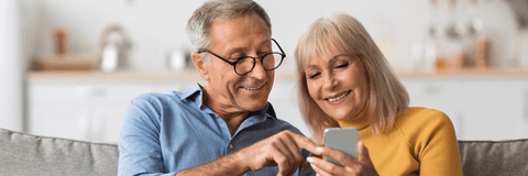 Older couple checking retirement accounts on phone