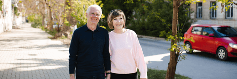Couple in their 60s walking on the sidewalk in neighborhood