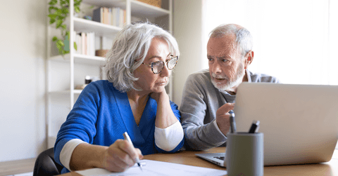 Boomer couple looking at emergency fund on laptop