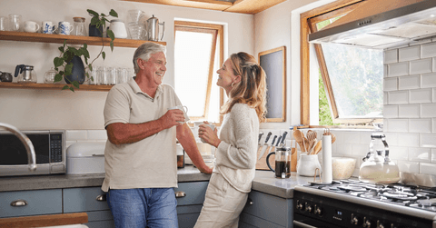 Couple in their 60s talking about social security in their kitchen