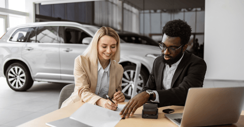 Woman signing papers to buy new car
