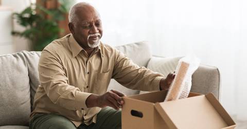 retired senior man packing stuff in box indoors