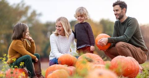 family in pumpkin patch field