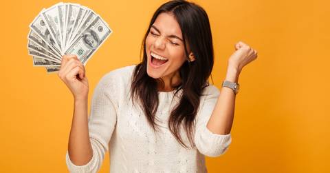 cheerful young woman holding money