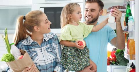 happy family arranging grocery in fridge