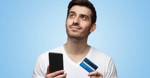 man holding smartphone and credit card