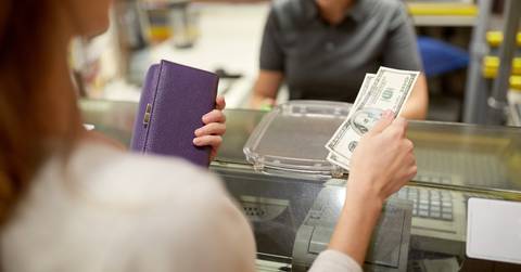 paying money at store cash register