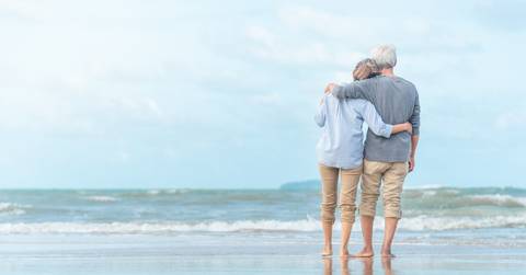 senior couple enjoying beachside waves