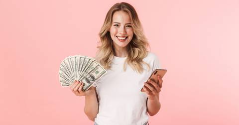 holding money and using phone