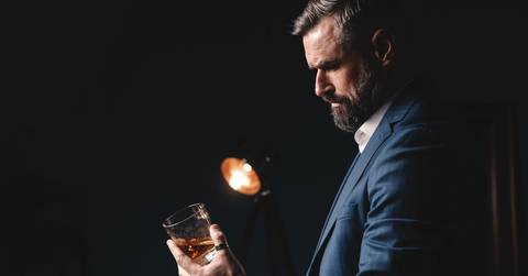 man holds glass of brandy