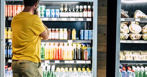 man besides drinks refrigerator
