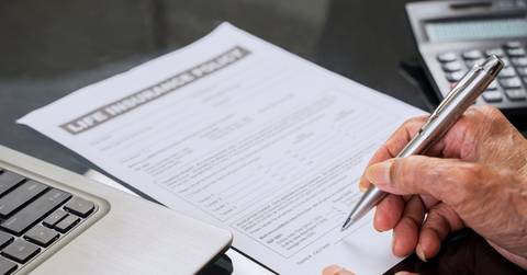 Senior man signing life insurance form 